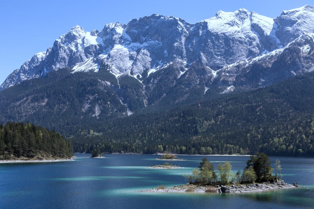 Vordergrund: blau und türkisfarbener See, Hintergrund: schneebedeckte Berge